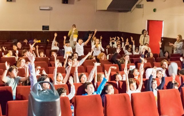 Copii în sala de cinema, cu mâinile ridicate, la ediția BKFF 2025