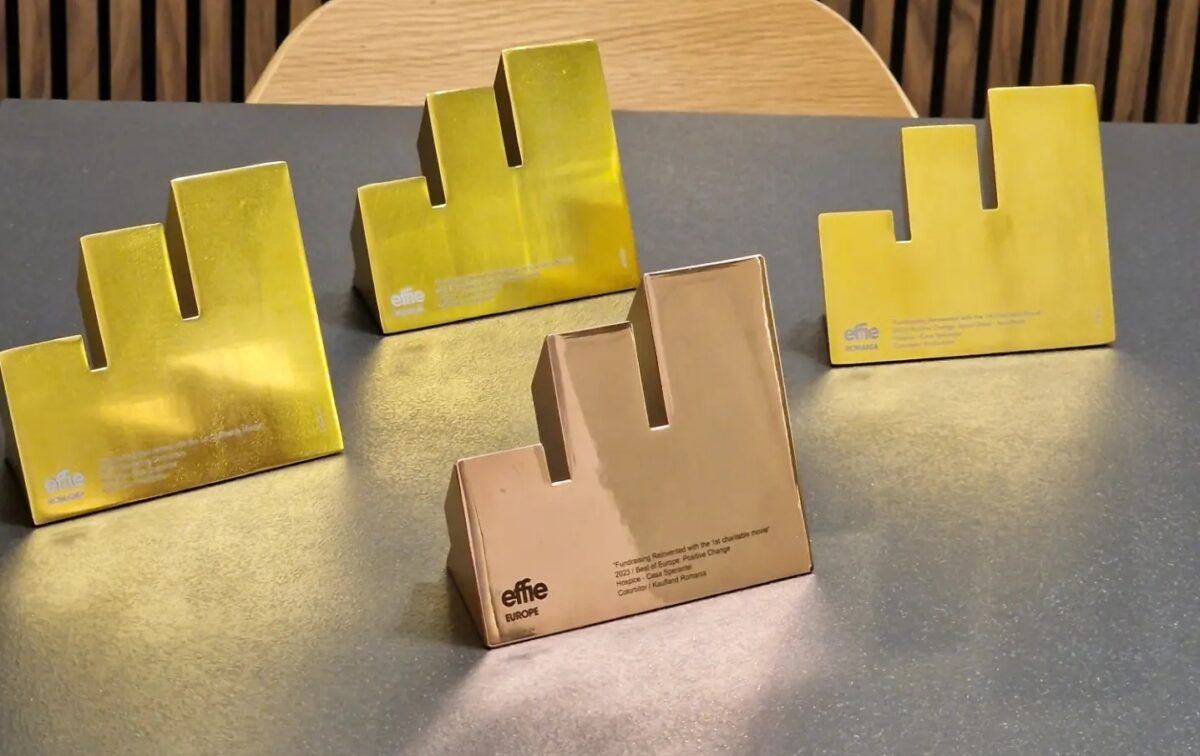 Four Effie trophies on a table, three gold and one bronze