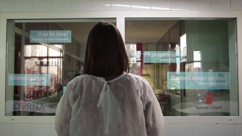 Detaliu al proiecției, cu mesaje de încurajare afișate pe geamul secției