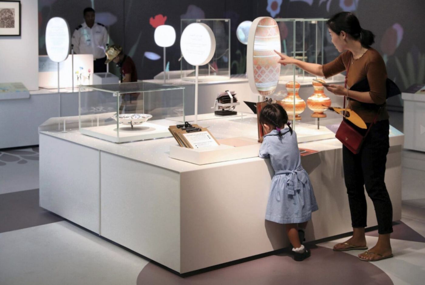 An adult and a child exploring one of the exhibition stations together