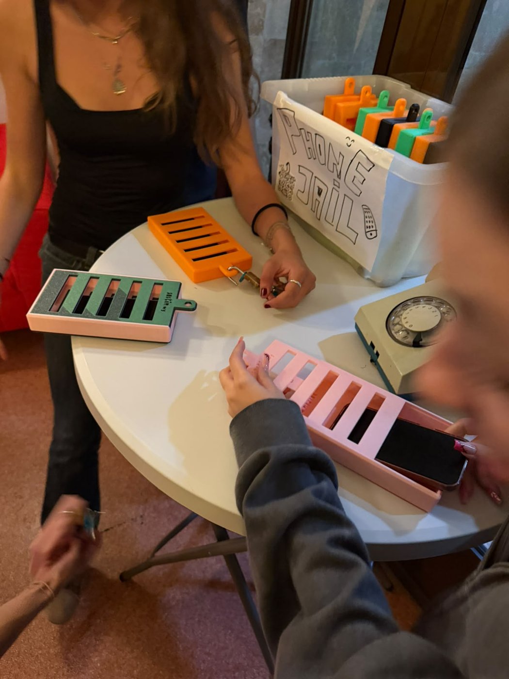 A phone locked inside an orange phone jail, held by a participant.