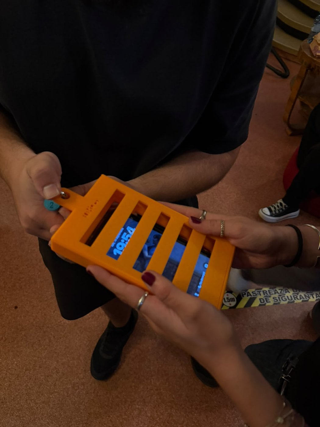 The padlock being closed on a phone jail case, on the foyer table.
